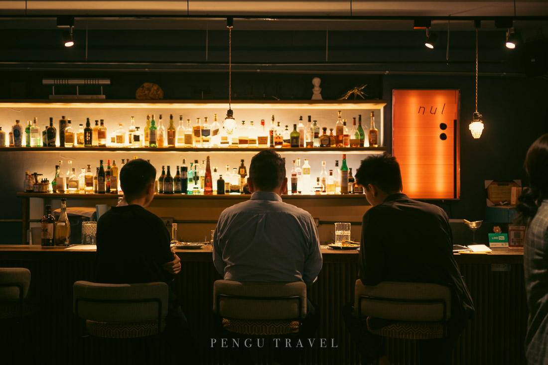 nul Taipei酒吧區：暖黃燈光下的極簡吧台設計，定格都市深夜的微醺社交氛圍。